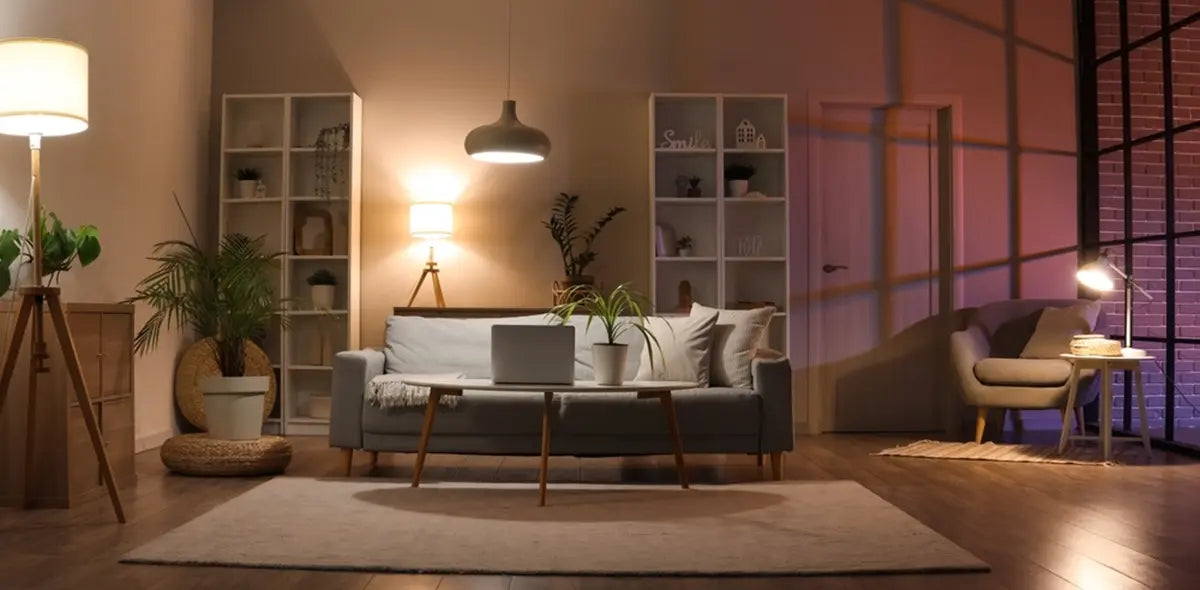 Interior of living room with sofa, armchair, table lamp and glowing lamps in evening