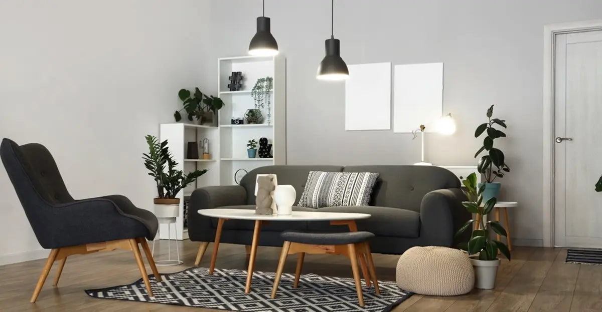 Interior of stylish living room with grey sofa, armchair and glowing table lamps at evening