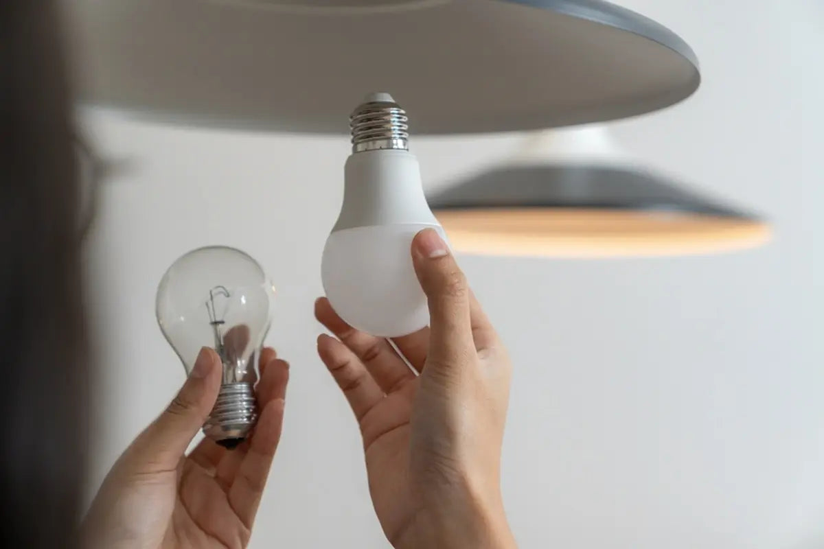 The young woman is changing led light bulbs at home