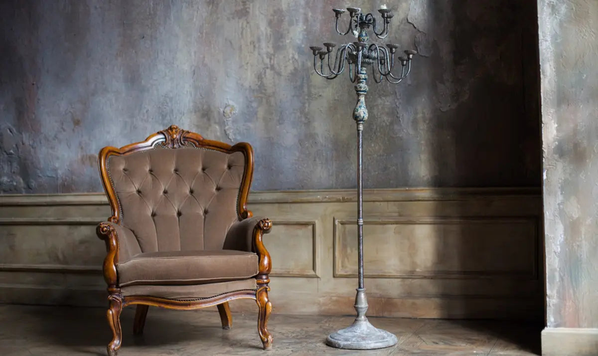 Vintage old metal floor lamp next to a classic brown armchair in a rustic room